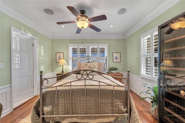 bedroom with multiple windows, ornamental molding, and wood finished floors