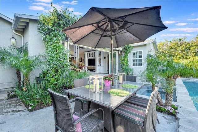 view of patio featuring outdoor dining area and an outdoor pool