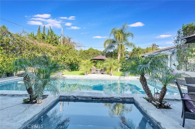 view of swimming pool with a pool with connected hot tub and a patio