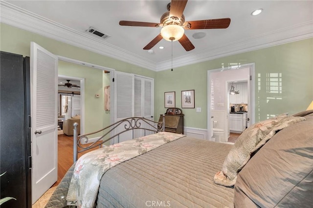 bedroom featuring ensuite bathroom, light wood-style flooring, recessed lighting, visible vents, and crown molding