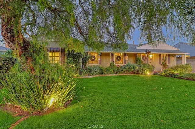 single story home with a front lawn and stucco siding