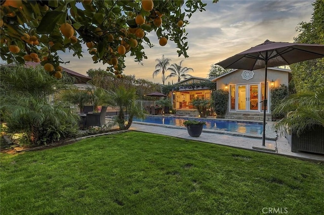 view of yard featuring a patio area, an outdoor pool, and french doors