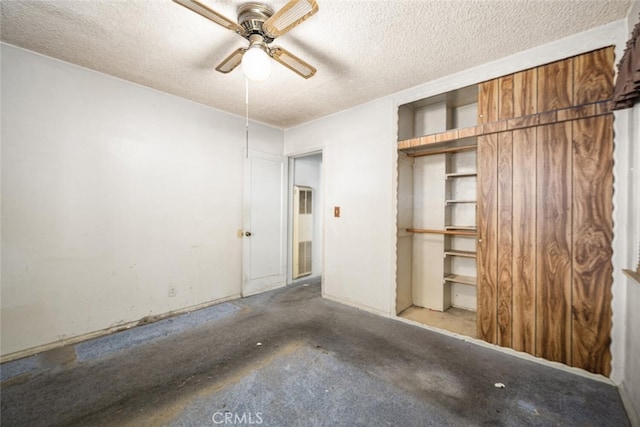 unfurnished bedroom featuring a textured ceiling, a closet, a ceiling fan, and unfinished concrete floors