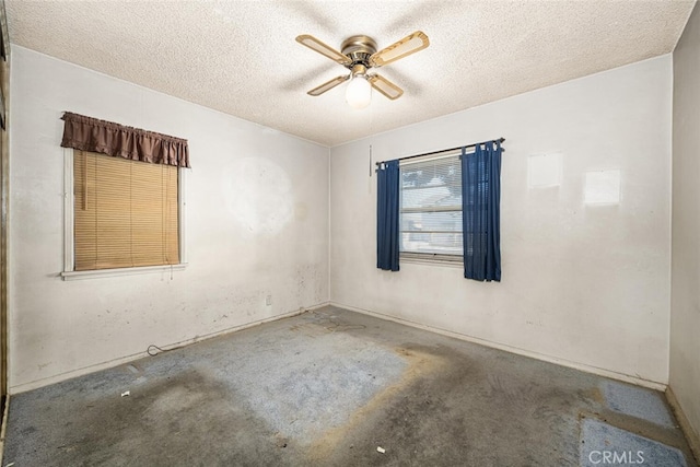 unfurnished room featuring ceiling fan and a textured ceiling