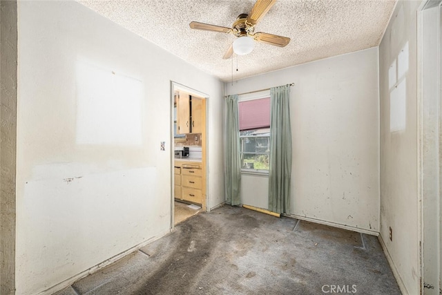 unfurnished room featuring a ceiling fan and a textured ceiling