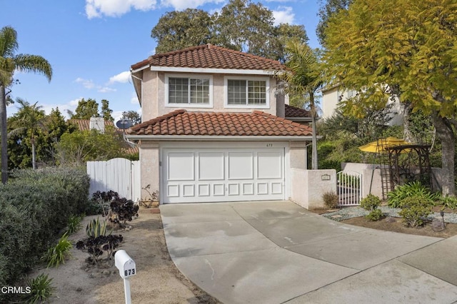 mediterranean / spanish home with a tile roof, a gate, and stucco siding