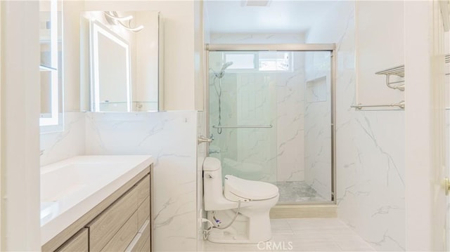bathroom with toilet, a marble finish shower, vanity, and tile walls