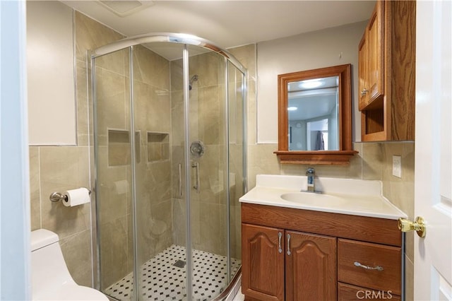bathroom featuring visible vents, toilet, a shower stall, and vanity