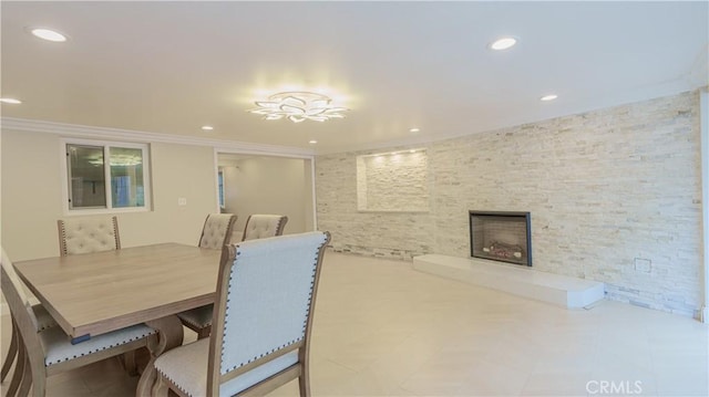 dining area featuring recessed lighting, a fireplace, and crown molding