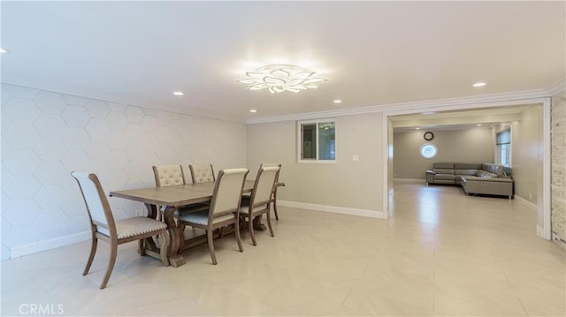 dining area featuring an accent wall, baseboards, and crown molding