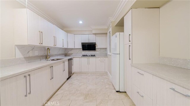 kitchen with a sink, ornamental molding, freestanding refrigerator, black cooktop, and decorative backsplash