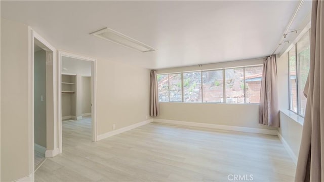 unfurnished room with baseboards and light wood finished floors