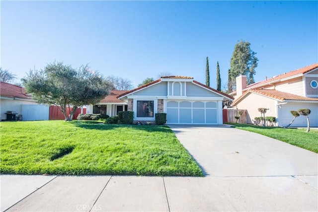 view of front of property with a tile roof, an attached garage, a front yard, fence, and driveway