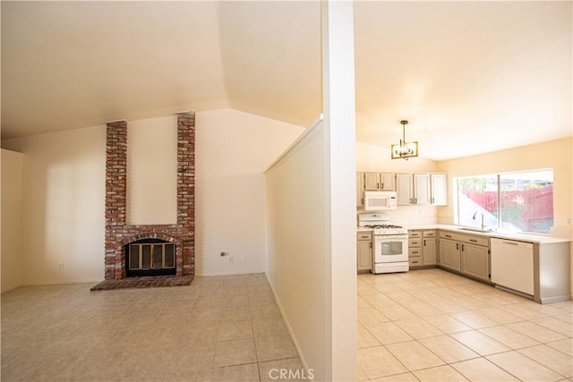 kitchen with white appliances, lofted ceiling, light countertops, a fireplace, and a sink