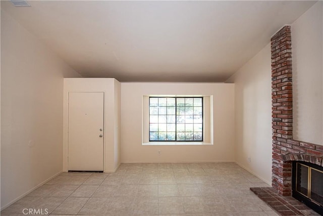 unfurnished living room with vaulted ceiling, a fireplace, and baseboards