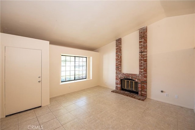 unfurnished living room with vaulted ceiling, light tile patterned floors, and a brick fireplace