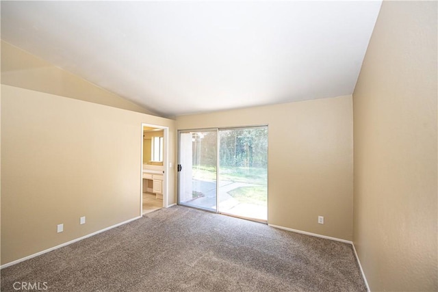 carpeted spare room featuring vaulted ceiling and baseboards