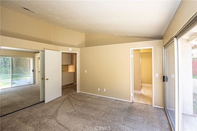 unfurnished bedroom featuring lofted ceiling, access to outside, carpet, and visible vents