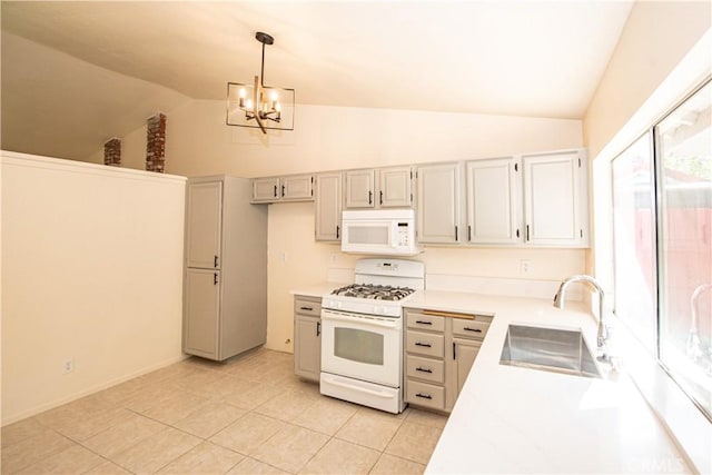 kitchen featuring decorative light fixtures, light countertops, vaulted ceiling, a sink, and white appliances