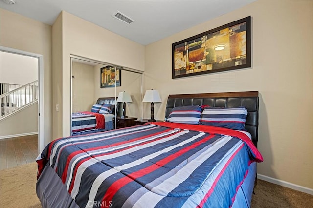 carpeted bedroom featuring baseboards, visible vents, and a closet