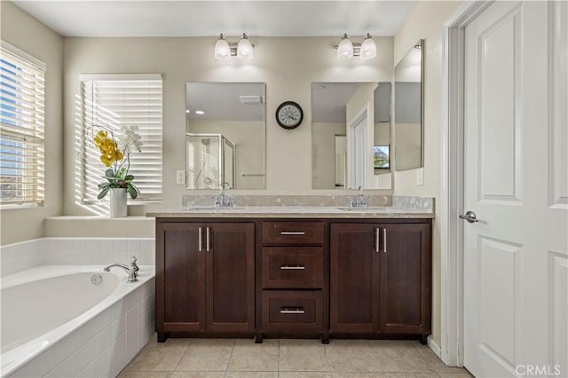 bathroom with a garden tub, a sink, a shower stall, tile patterned floors, and double vanity