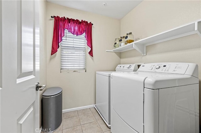 laundry room featuring light tile patterned floors, laundry area, washing machine and clothes dryer, and baseboards