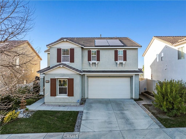 traditional-style home featuring a garage, solar panels, a tiled roof, driveway, and stucco siding