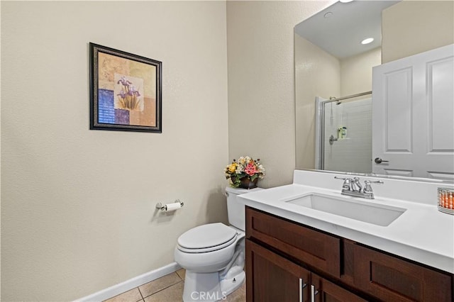 bathroom featuring a stall shower, baseboards, toilet, tile patterned flooring, and vanity