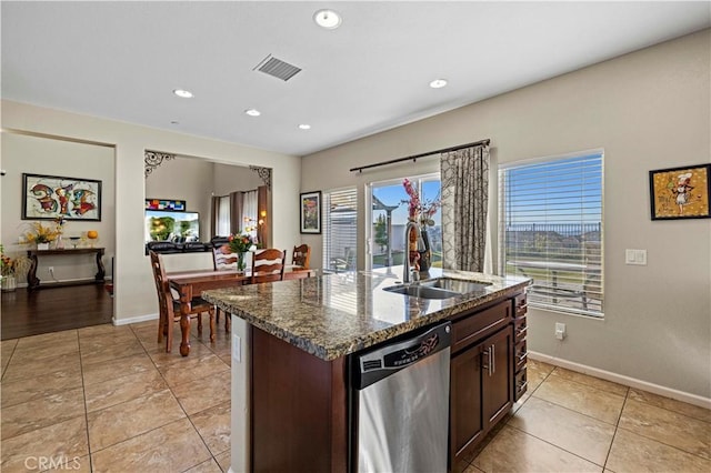 kitchen featuring a center island with sink, visible vents, a sink, dark stone countertops, and dishwasher