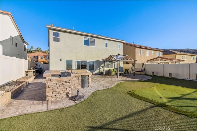 rear view of property with a patio, an outdoor kitchen, a fenced backyard, a residential view, and stucco siding