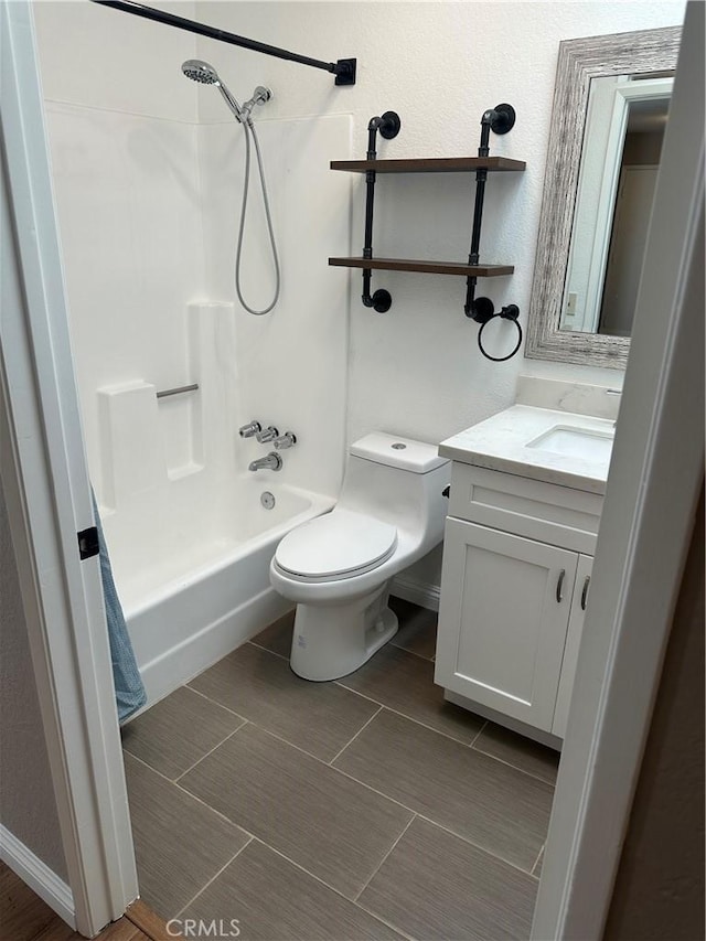 bathroom featuring washtub / shower combination, baseboards, vanity, and toilet