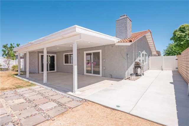 17875 Idyllwild Ln, Victorville, CA 92395 - rear view of house featuring stucco siding, a fenced backyard, a patio area, and a tile roof