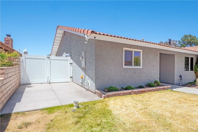 17875 Idyllwild Ln, Victorville, CA 92395 - rear view of house featuring a gate, stucco siding, a tiled roof, and a patio area