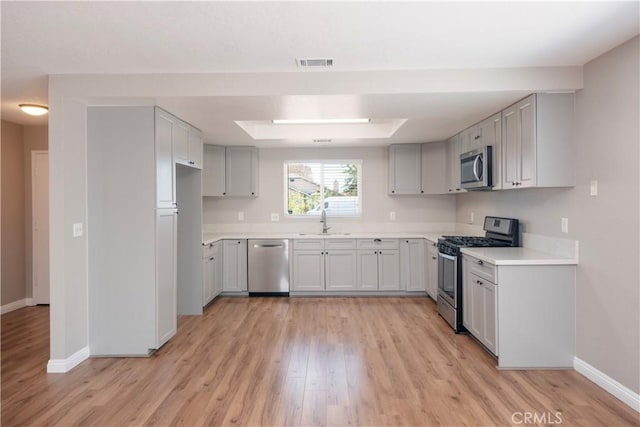 17875 Idyllwild Ln, Victorville, CA 92395 - kitchen featuring appliances with stainless steel finishes, a sink, baseboards, light wood-type flooring, and light countertops