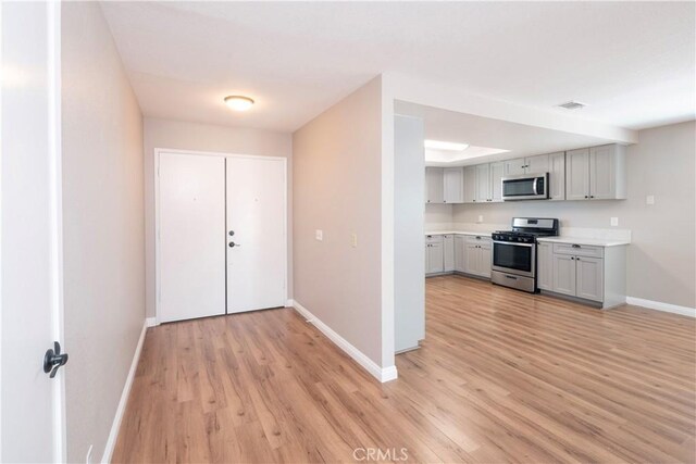 17875 Idyllwild Ln, Victorville, CA 92395 - kitchen featuring appliances with stainless steel finishes, baseboards, light wood finished floors, light countertops, and gray cabinetry
