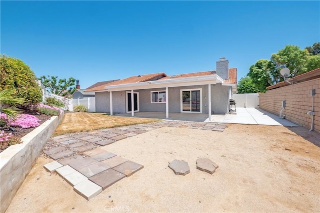 17875 Idyllwild Ln, Victorville, CA 92395 - back of house with a chimney, a patio, a fenced backyard, and stucco siding