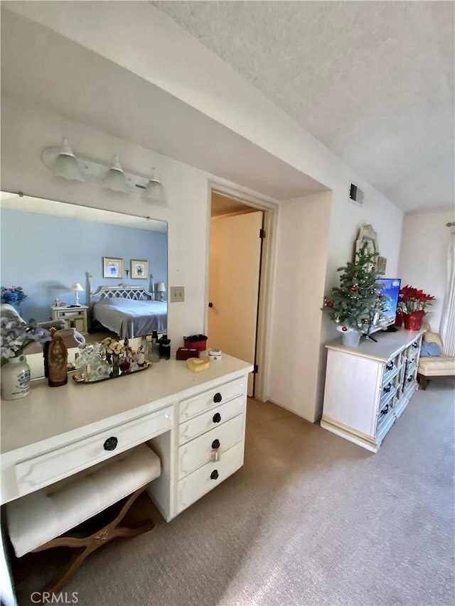 interior space featuring carpet, white cabinetry, light countertops, and a textured ceiling