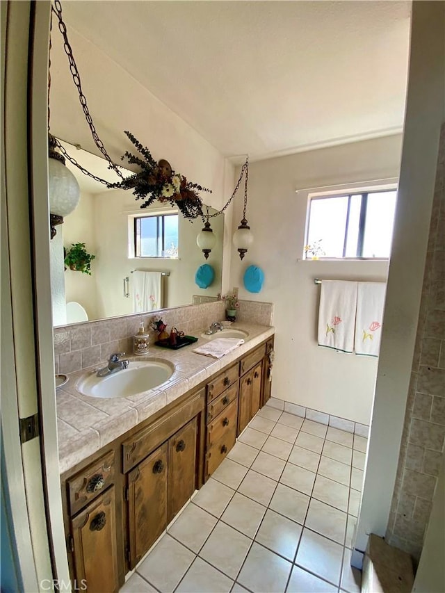 bathroom featuring double vanity, a wealth of natural light, a sink, and tile patterned floors