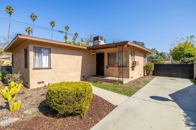 ranch-style house featuring crawl space, fence, cooling unit, and stucco siding