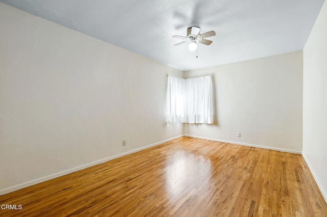 unfurnished room featuring baseboards, light wood-style flooring, and a ceiling fan