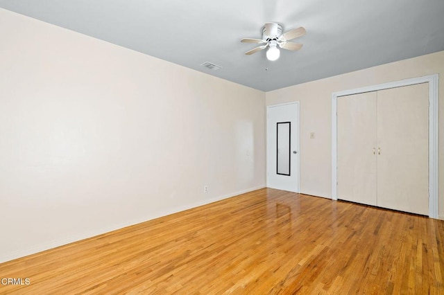 unfurnished bedroom featuring light wood finished floors, a closet, visible vents, ceiling fan, and baseboards