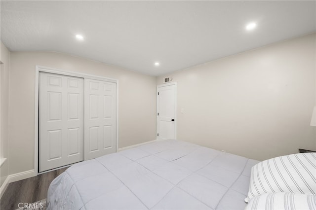 bedroom with a closet, visible vents, dark wood-type flooring, and recessed lighting