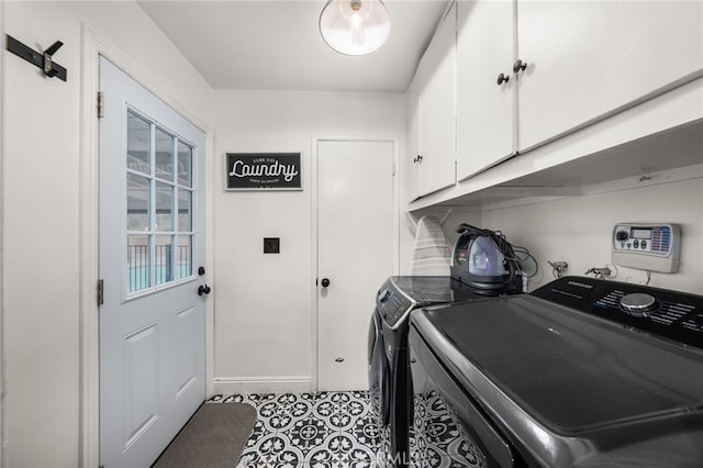 clothes washing area featuring independent washer and dryer, cabinet space, and tile patterned floors