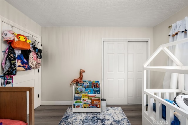 bedroom with a closet, a textured ceiling, and dark wood-type flooring