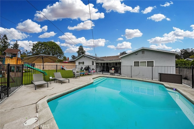 view of pool featuring a patio, a playground, fence, and a fenced in pool