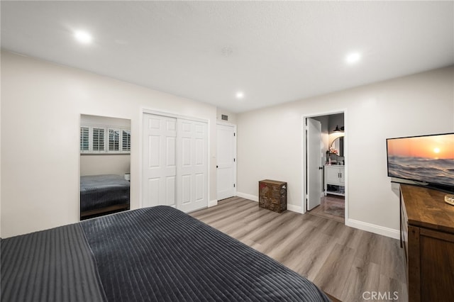 unfurnished bedroom featuring baseboards, a closet, visible vents, and light wood-style floors