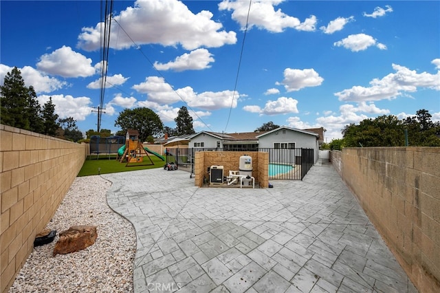 exterior space with a patio, a playground, a fenced backyard, and a fenced in pool