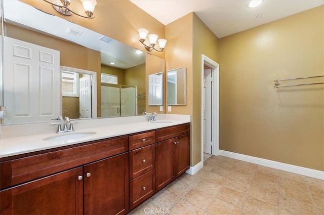 full bath with a sink, a shower stall, baseboards, and double vanity