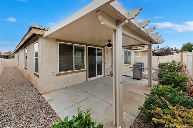 back of house featuring a fenced backyard, a tiled roof, a patio, and stucco siding