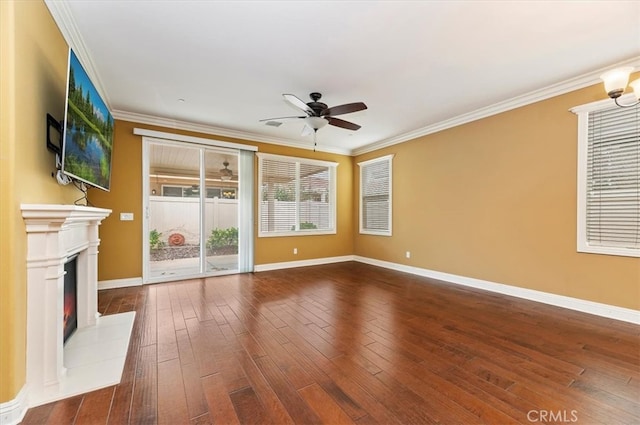 unfurnished living room with dark wood-style floors, baseboards, a glass covered fireplace, and crown molding